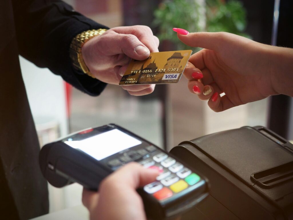 credit card handed over to cashier holding a wireless POS for payment